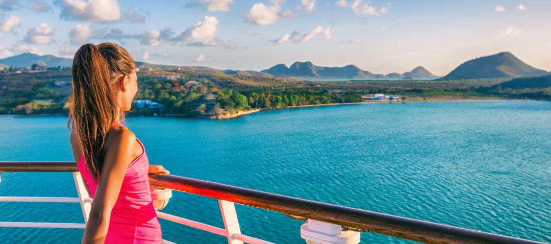 cruise ship woman a young woman looks over the rail of a cruise ship at the Caribbean coast