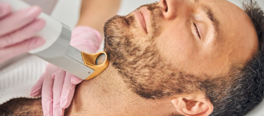 a man receives a laser treatment on his neck beneath the beard