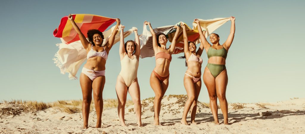 Friends flying their towels at the beach